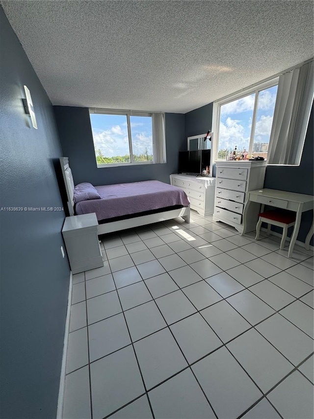 unfurnished bedroom featuring light tile patterned floors, a textured ceiling, and multiple windows