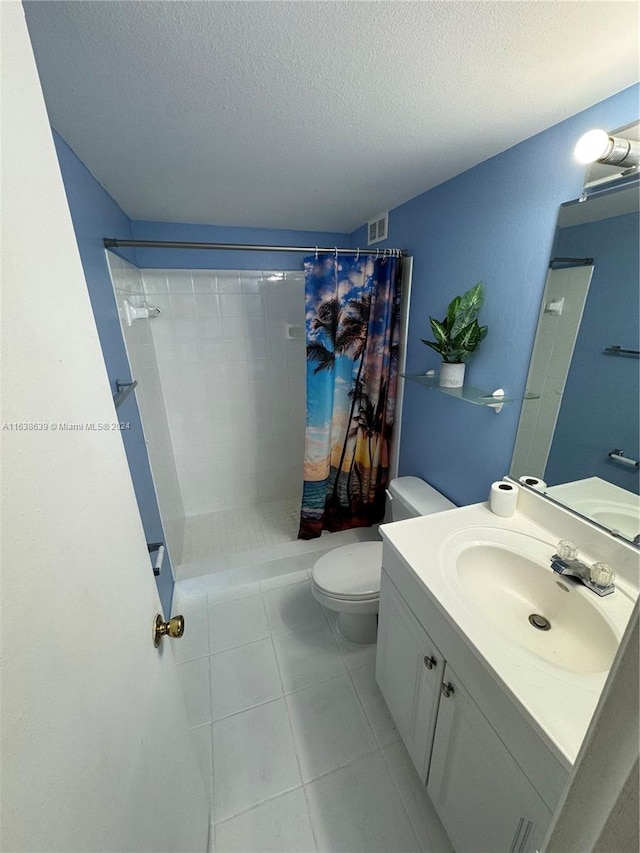 bathroom with a textured ceiling, toilet, tile patterned flooring, a shower with curtain, and vanity