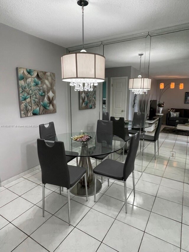 tiled dining room featuring a textured ceiling