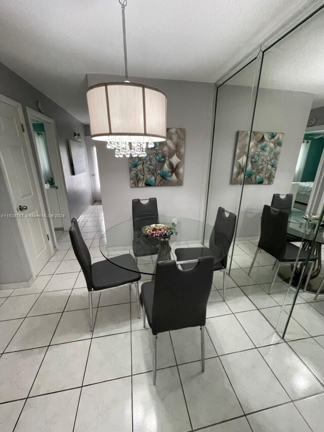 tiled dining area featuring a chandelier