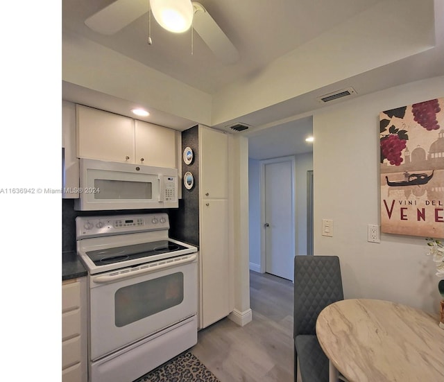 1825 S Ocean Dr Unit 206, Hallandale Beach, FL 33009 - kitchen with white appliances, white cabinets, ceiling fan, dark countertops, and light wood finished floors