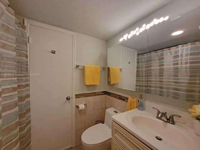 bathroom with tile walls, toilet, and vanity