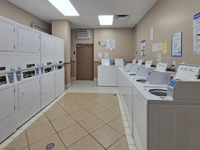 laundry room featuring stacked washer / dryer, washing machine and clothes dryer, and light tile patterned floors