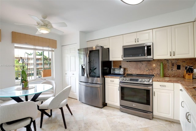 kitchen with light tile patterned floors, appliances with stainless steel finishes, backsplash, and white cabinets