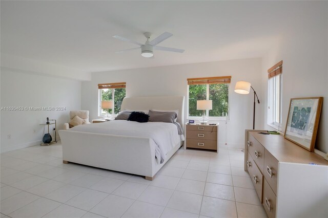 tiled bedroom featuring ceiling fan and multiple windows