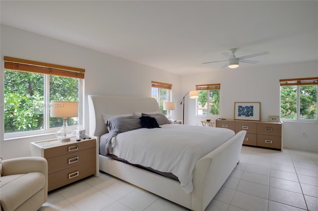 tiled bedroom with ceiling fan and multiple windows