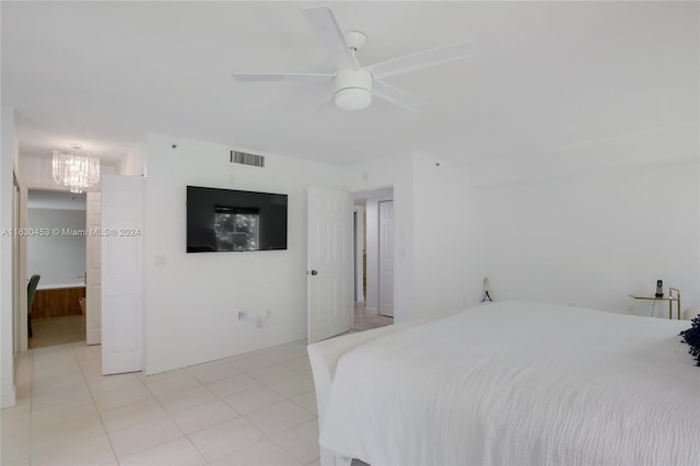 tiled bedroom with ceiling fan with notable chandelier