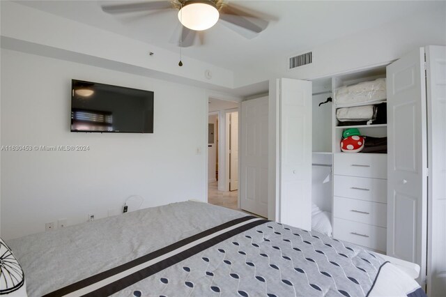 carpeted bedroom featuring ceiling fan and a closet