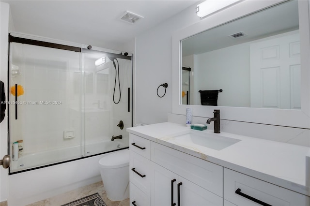 full bathroom with shower / bath combination with glass door, toilet, vanity, and tile patterned floors