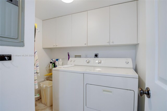 washroom featuring washing machine and dryer and cabinets