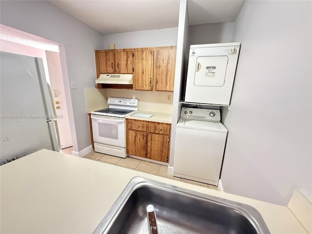 440 E 23rd St Unit 1219, Hialeah, FL 33013 - kitchen featuring white appliances, under cabinet range hood, stacked washer / drying machine, light countertops, and brown cabinets