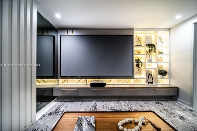 cinema room with built in desk and wood-type flooring