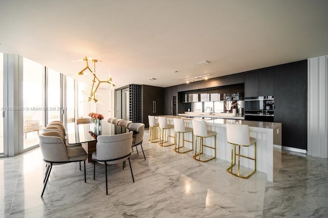 interior space featuring oven, sink, a kitchen island, black oven, and floor to ceiling windows