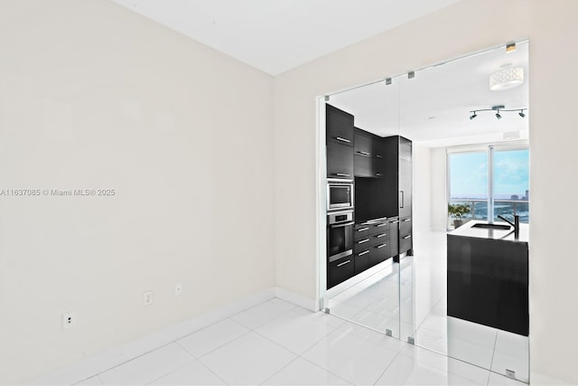 kitchen with stainless steel oven and light tile patterned floors