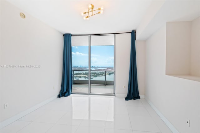 unfurnished room featuring floor to ceiling windows and light tile patterned floors