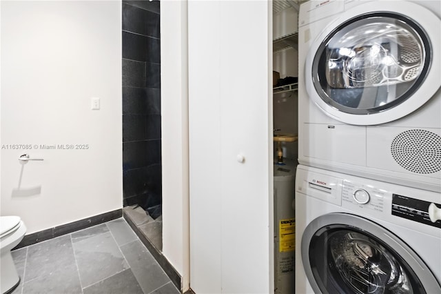 clothes washing area with water heater and stacked washer / drying machine