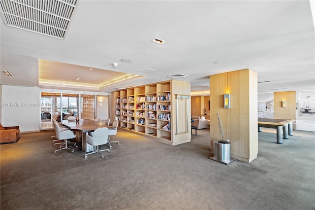 dining space with carpet flooring and a raised ceiling