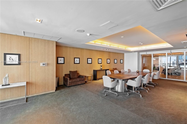 carpeted dining room featuring a raised ceiling