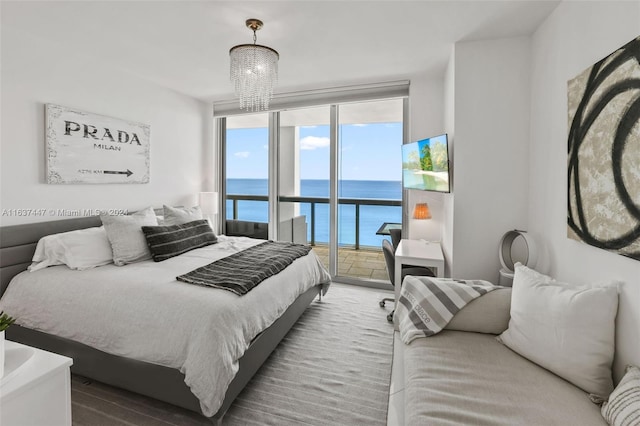 bedroom with access to outside, a chandelier, and expansive windows