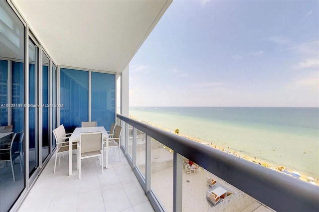 balcony featuring a water view and a beach view