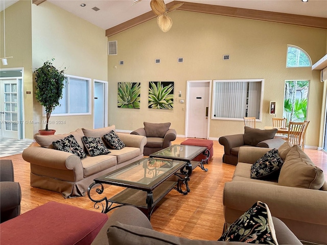 living room with light hardwood / wood-style flooring, beam ceiling, and high vaulted ceiling