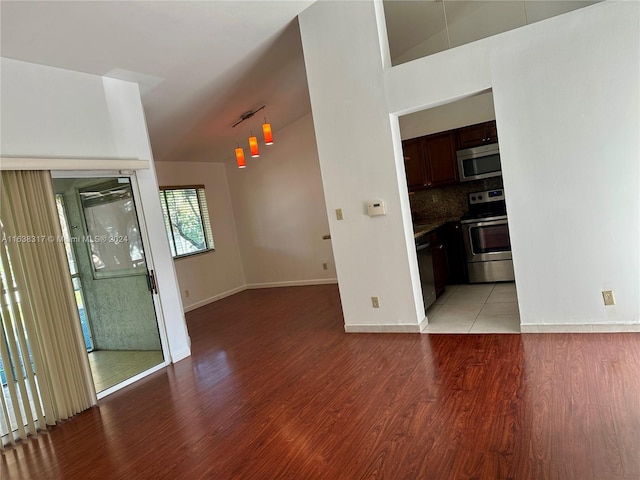 unfurnished room with light hardwood / wood-style flooring and lofted ceiling