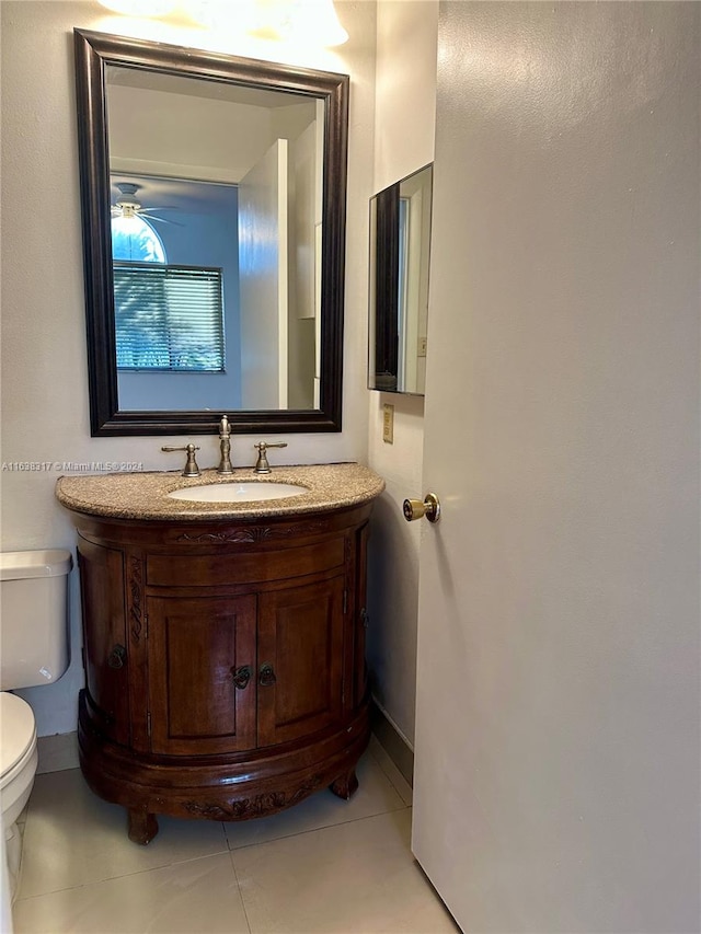 bathroom featuring tile patterned flooring, vanity, toilet, and ceiling fan