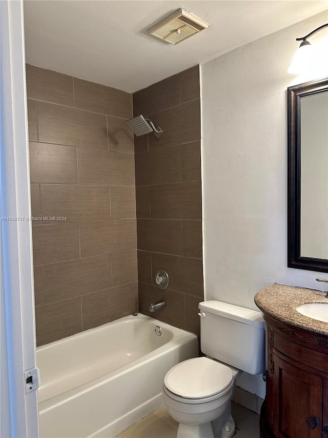 full bathroom with tile patterned flooring, a textured ceiling, vanity, tiled shower / bath, and toilet