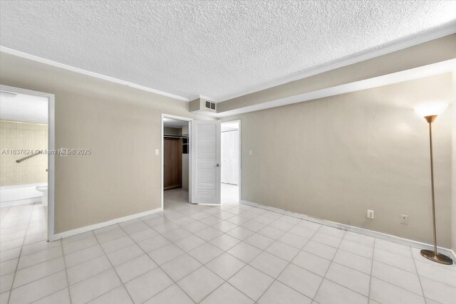 spare room with crown molding and light tile patterned floors