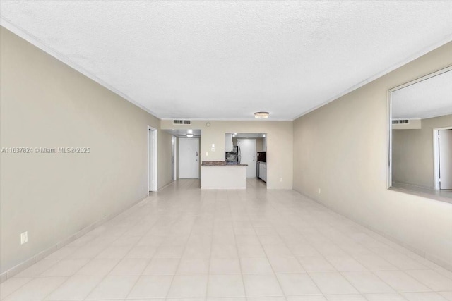 unfurnished living room with visible vents, a textured ceiling, and ornamental molding