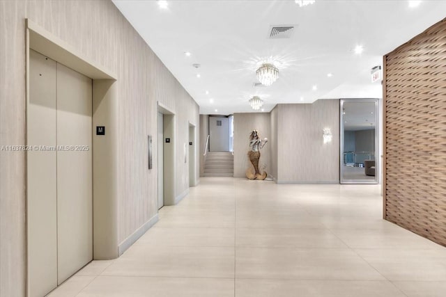 hallway featuring elevator and light tile patterned floors