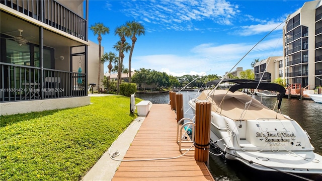 view of dock featuring a lawn and a water view