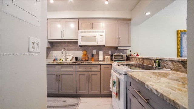 kitchen with white appliances, decorative backsplash, sink, and gray cabinets