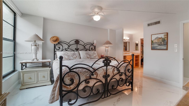 bedroom featuring ceiling fan, light tile patterned flooring, and ensuite bath