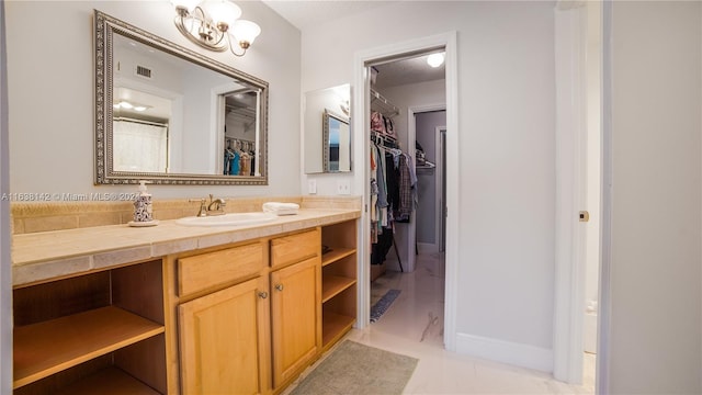 bathroom with vanity, tile patterned flooring, and an inviting chandelier