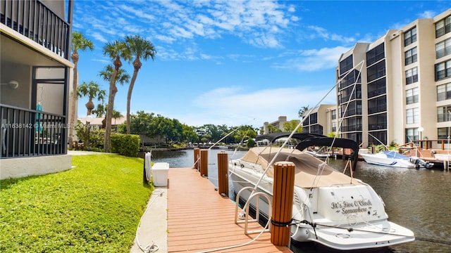 view of dock with a water view and a yard