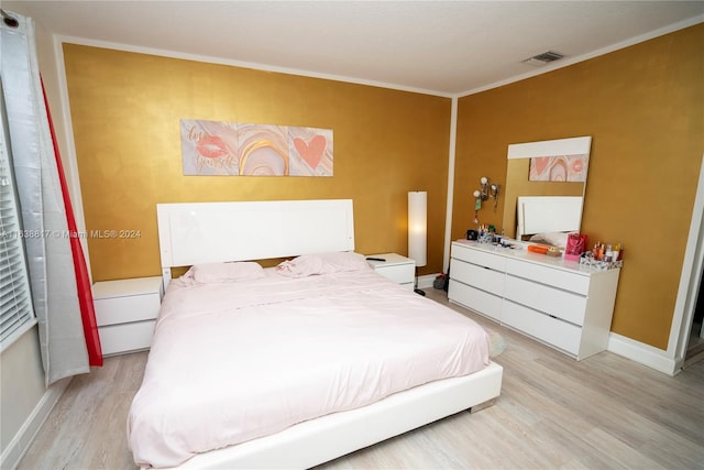 bedroom featuring light hardwood / wood-style floors and ornamental molding