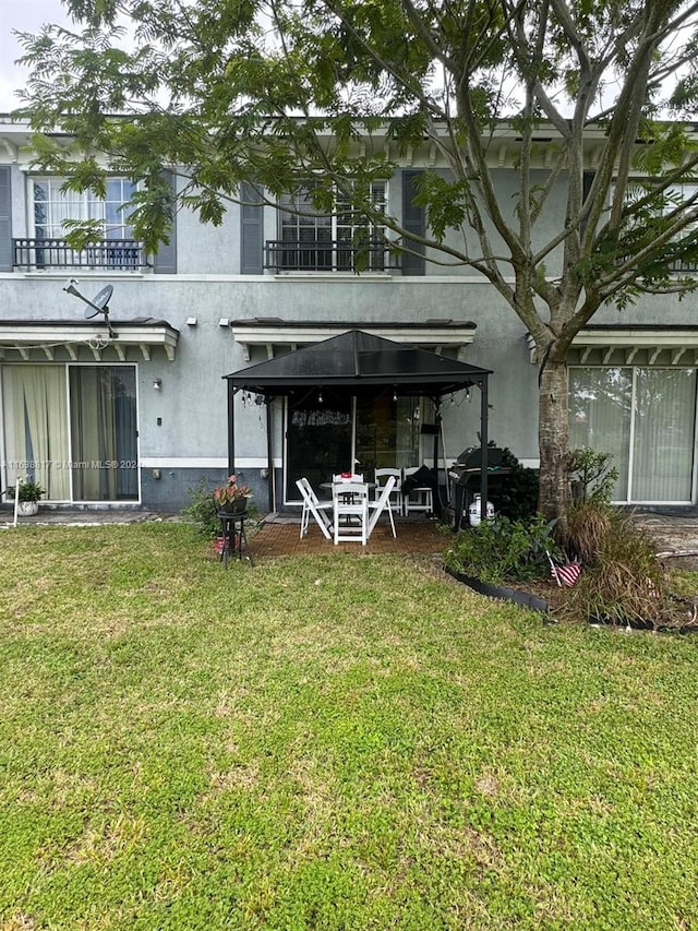 back of house featuring a yard and a gazebo