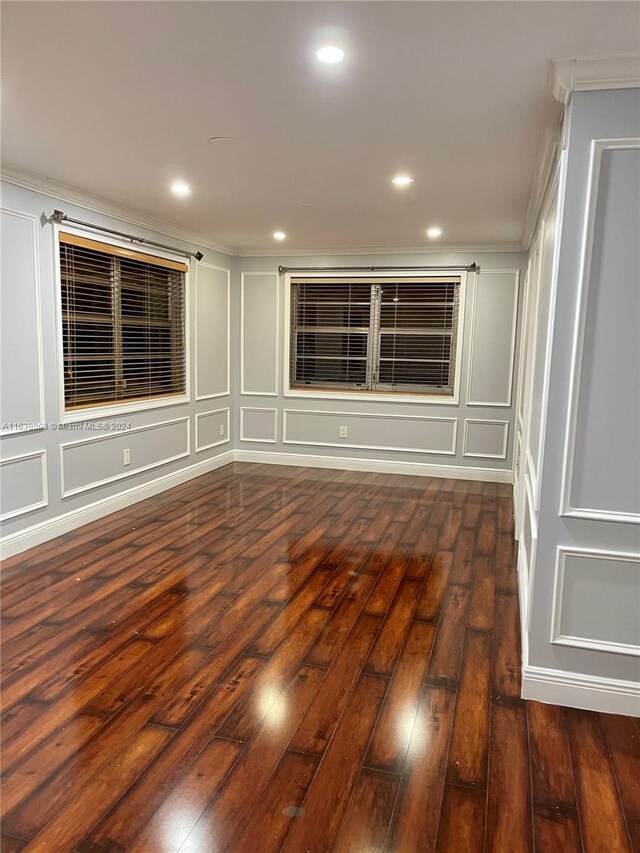 unfurnished living room featuring dark hardwood / wood-style floors and crown molding