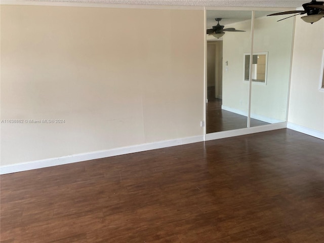 empty room featuring ceiling fan and dark hardwood / wood-style flooring