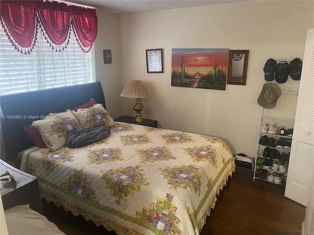 bedroom with dark hardwood / wood-style flooring and a textured ceiling