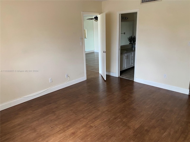 empty room featuring ceiling fan and dark wood-type flooring