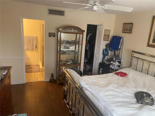 bedroom featuring a textured ceiling, ceiling fan, connected bathroom, dark hardwood / wood-style floors, and a closet