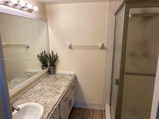 bathroom featuring vanity, hardwood / wood-style flooring, and an enclosed shower