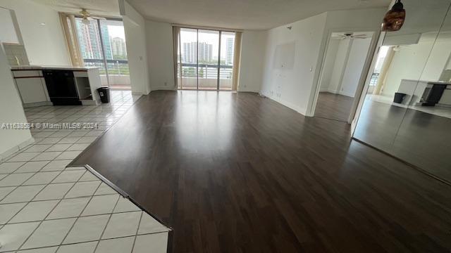 unfurnished living room with ceiling fan, light wood-type flooring, and floor to ceiling windows