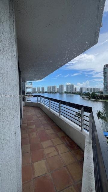 view of patio featuring a water view and a balcony