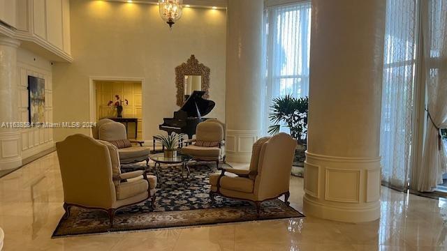 sitting room with ornate columns and light tile patterned floors