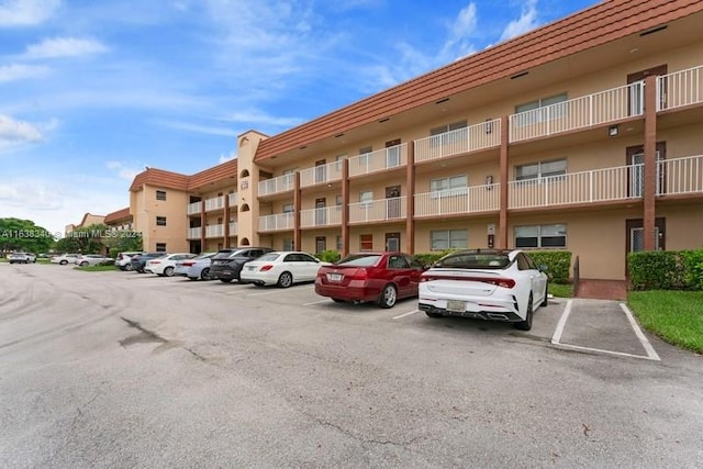 view of building exterior with uncovered parking