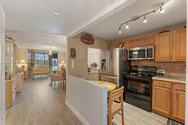 kitchen featuring appliances with stainless steel finishes, light hardwood / wood-style flooring, track lighting, and decorative backsplash