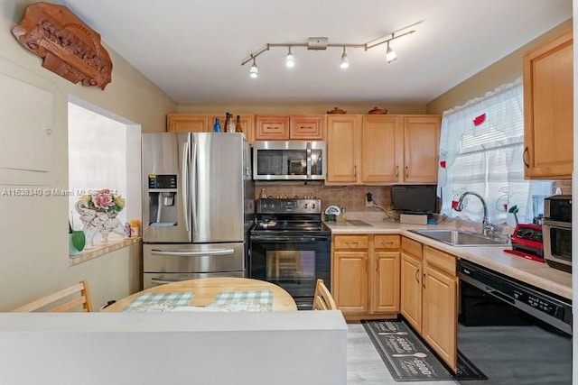 kitchen with backsplash, light countertops, black appliances, light brown cabinets, and a sink